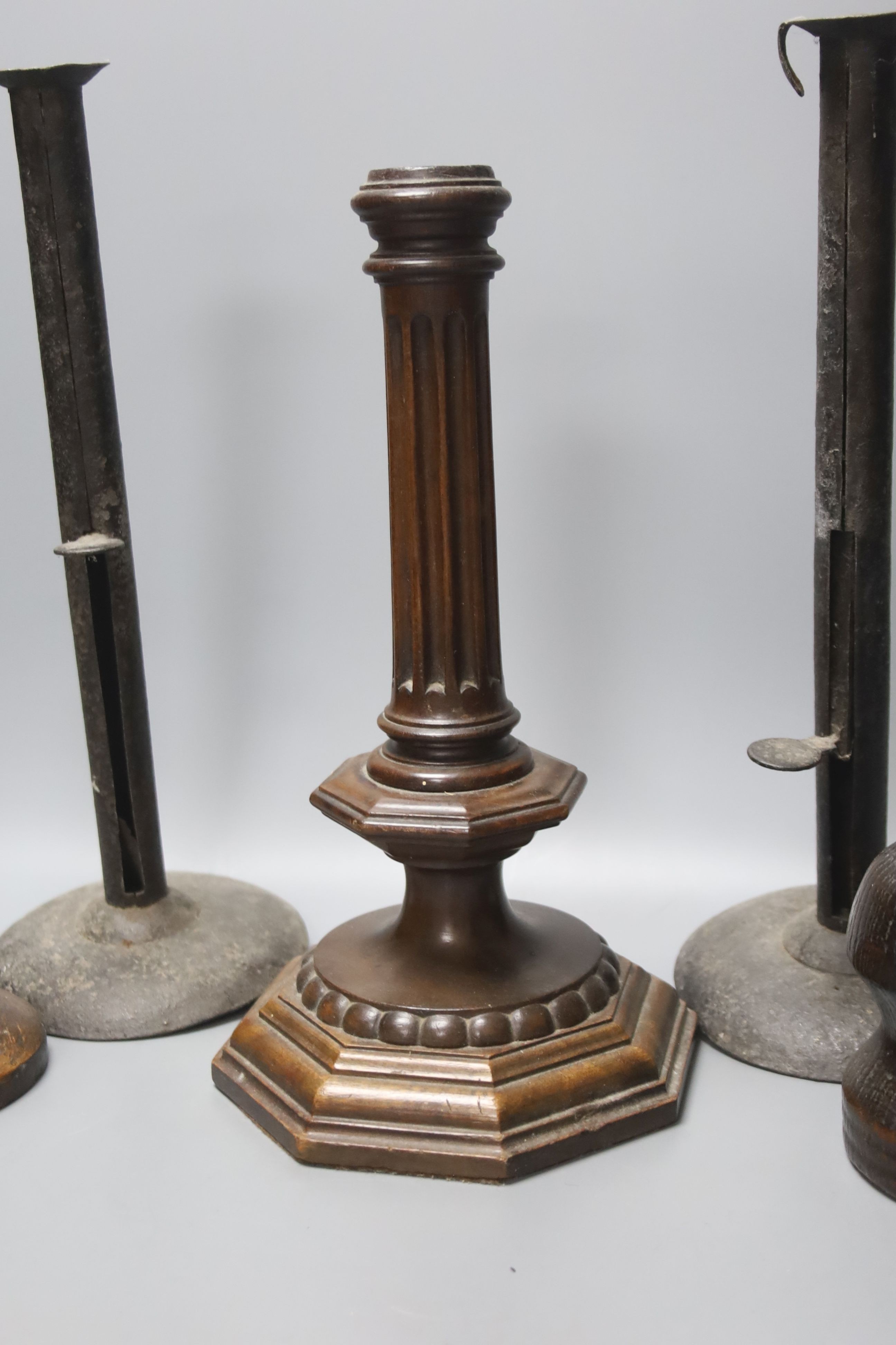 A wrought iron taperstick, a pair of iron telescopic candlesticks, a spiral candlestick, all Georgian and a 17th century style carved wood candlestick (5)